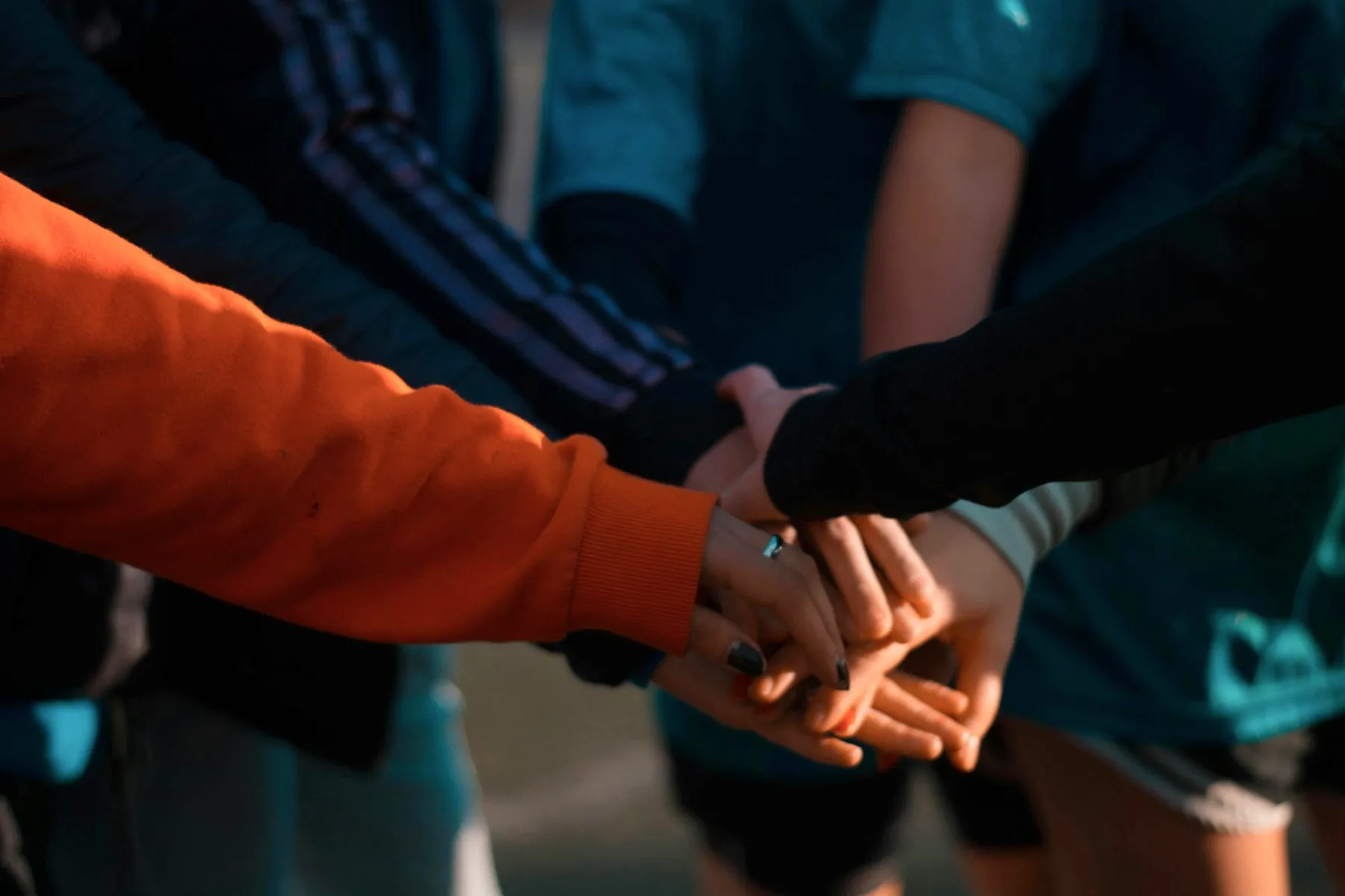 The Jrise team - hands joined together